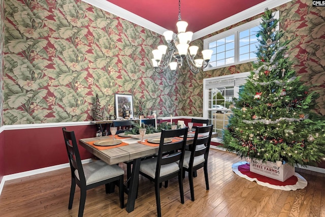 dining room with hardwood / wood-style flooring, crown molding, and a chandelier