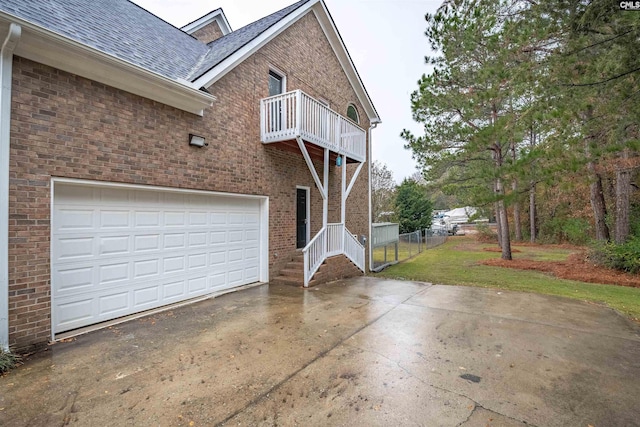 view of property exterior with a balcony and a garage