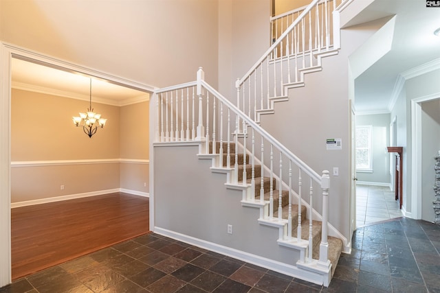 stairs featuring hardwood / wood-style floors, ornamental molding, and a notable chandelier