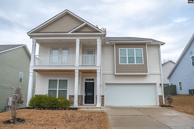 view of front of house with a balcony, a garage, and cooling unit