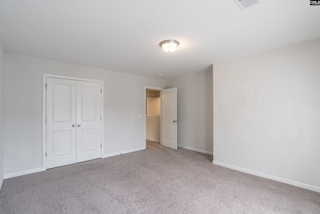 unfurnished bedroom featuring carpet and a closet