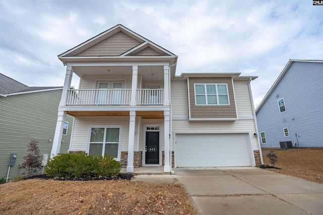 view of front of property with a balcony, a garage, and central AC unit