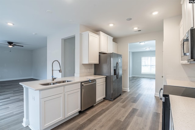 kitchen with appliances with stainless steel finishes, ceiling fan, sink, light hardwood / wood-style floors, and white cabinetry