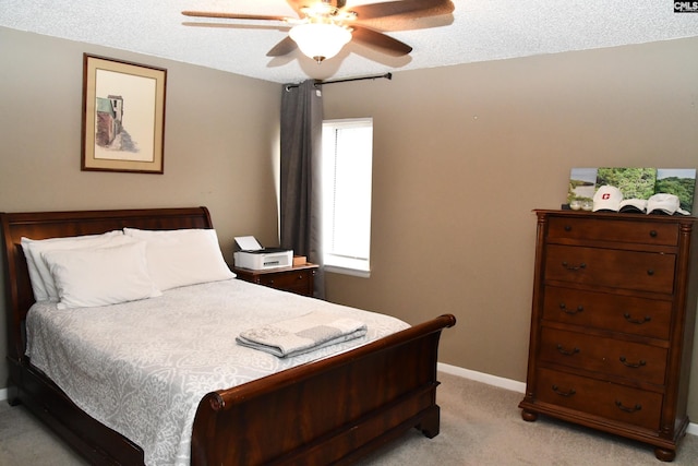 bedroom with ceiling fan, light colored carpet, and a textured ceiling