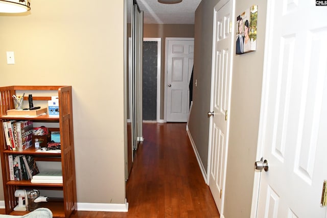 hallway featuring dark hardwood / wood-style floors and a textured ceiling