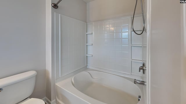 bathroom featuring tiled shower / bath combo and toilet