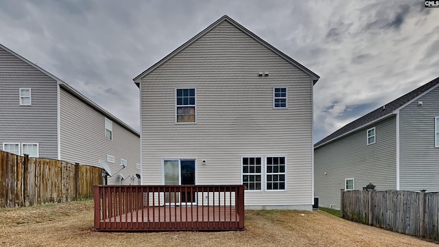 back of property featuring a deck and a lawn