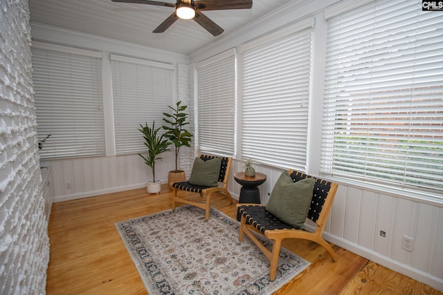 sitting room with light wood-type flooring, ceiling fan, and ornamental molding