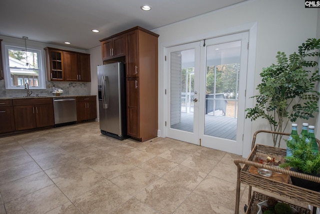 kitchen with appliances with stainless steel finishes, backsplash, french doors, and sink