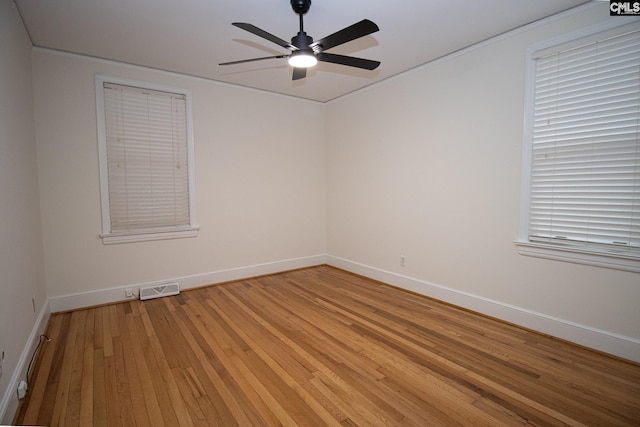 empty room with ceiling fan and light hardwood / wood-style flooring