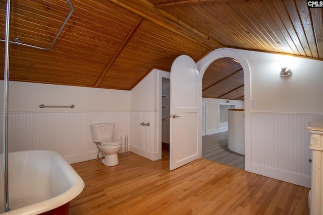 bathroom with a bathing tub, wood ceiling, vaulted ceiling, and wood-type flooring