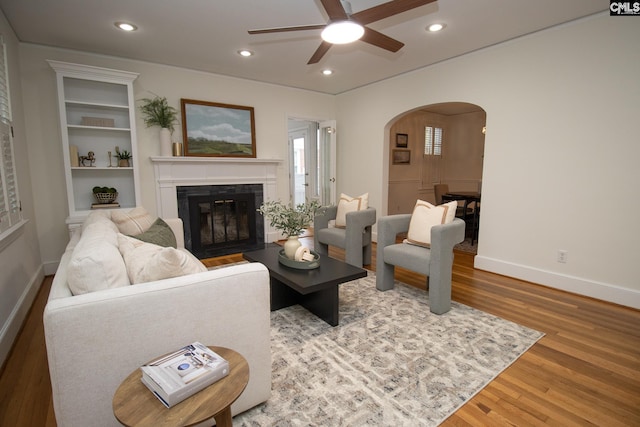 living room featuring wood-type flooring and ceiling fan