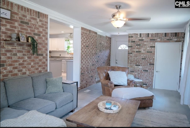 living room with light tile patterned floors, ornamental molding, and brick wall