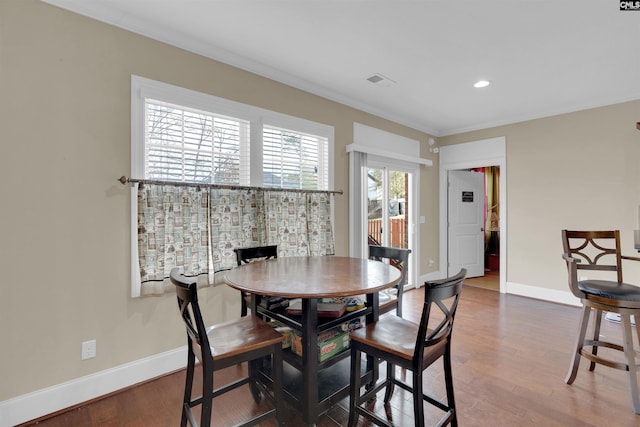 dining area featuring crown molding and hardwood / wood-style floors