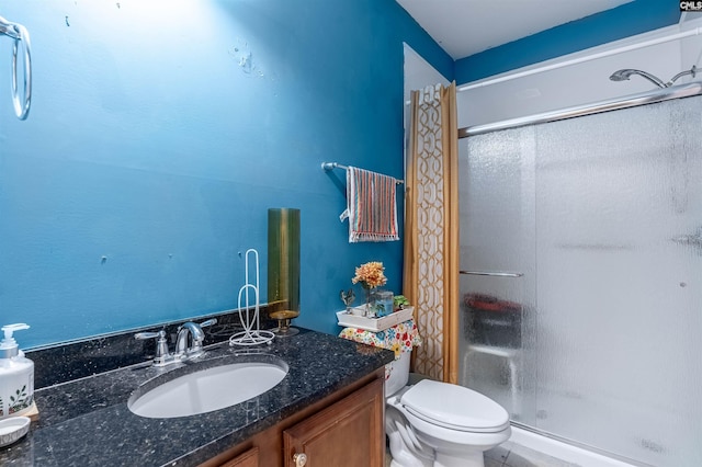 bathroom featuring a shower, vanity, and toilet