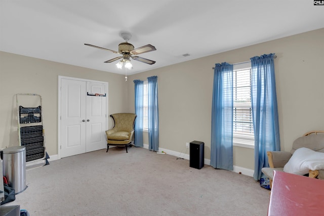 sitting room featuring light carpet and ceiling fan