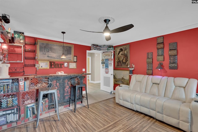 living room with ceiling fan, crown molding, and wood-type flooring