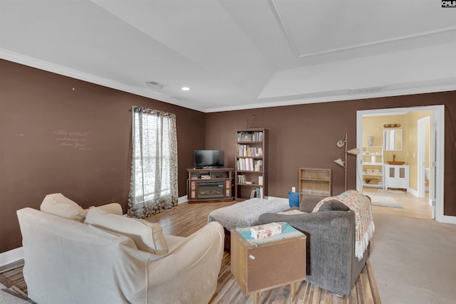 living room with a fireplace, light wood-type flooring, and crown molding