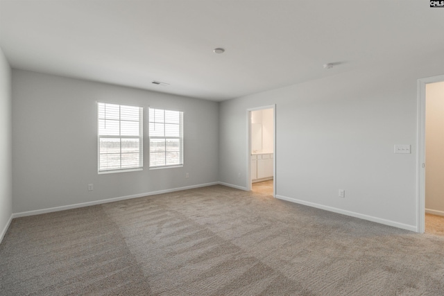 spare room featuring light colored carpet