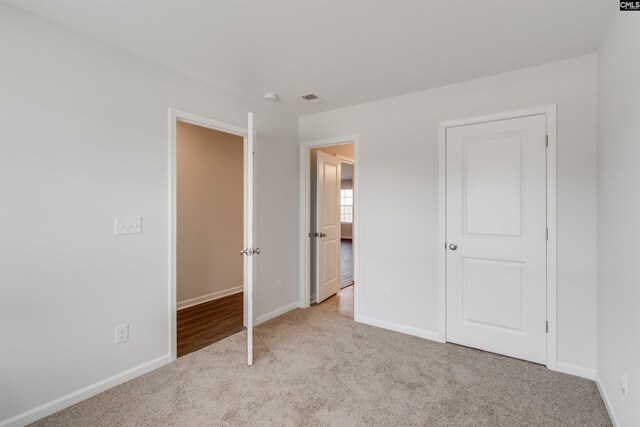 unfurnished bedroom featuring light carpet