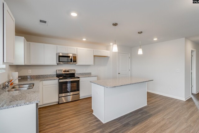 kitchen with a kitchen island, sink, white cabinetry, and stainless steel appliances