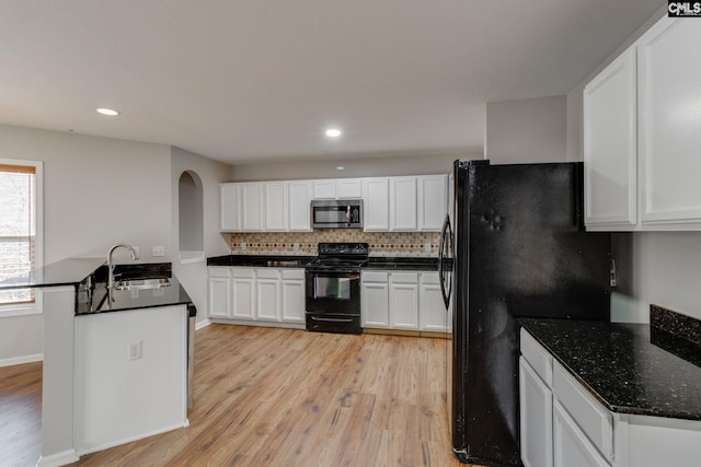 kitchen with backsplash, black appliances, white cabinets, sink, and light wood-type flooring