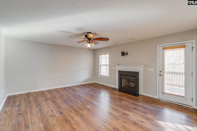 unfurnished living room featuring ceiling fan, a healthy amount of sunlight, and wood-type flooring