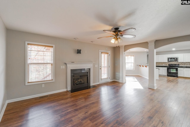 unfurnished living room featuring ceiling fan and dark hardwood / wood-style floors