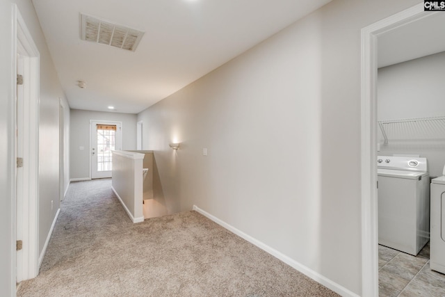 hallway featuring washer and dryer and light carpet