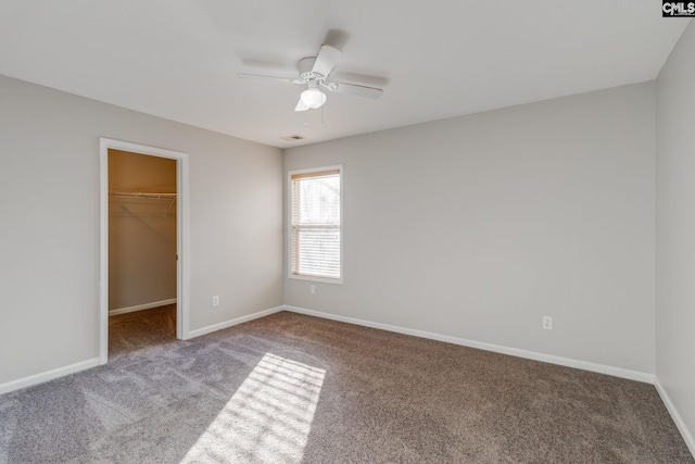 unfurnished bedroom featuring ceiling fan, light colored carpet, a walk in closet, and a closet