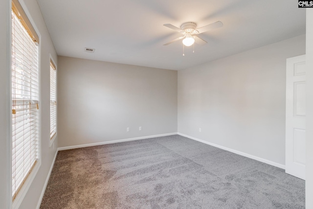 unfurnished room with ceiling fan and carpet