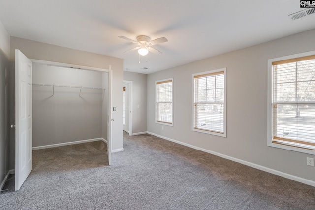 unfurnished bedroom with carpet, ceiling fan, a closet, and multiple windows