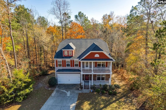 view of front of house with covered porch, a garage, and a front yard