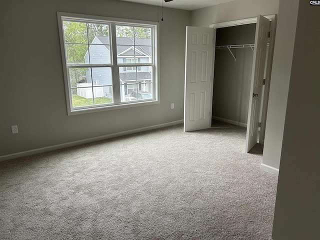 unfurnished bedroom featuring a closet, baseboards, and carpet flooring