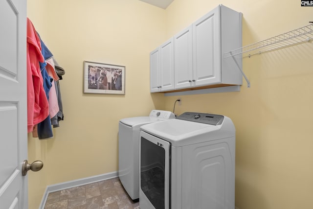 clothes washing area with cabinets and independent washer and dryer