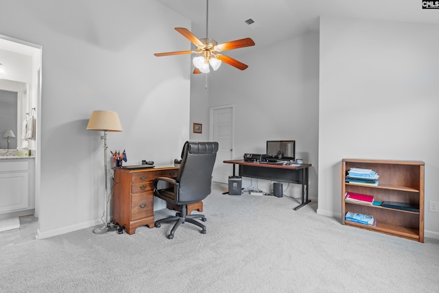 carpeted office with ceiling fan and high vaulted ceiling