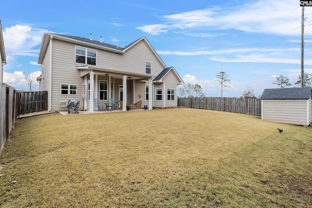 back of house featuring a patio, a storage shed, and a lawn