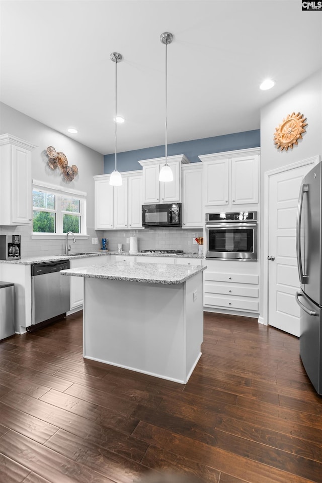 kitchen featuring stainless steel appliances, a center island, dark hardwood / wood-style floors, white cabinetry, and hanging light fixtures