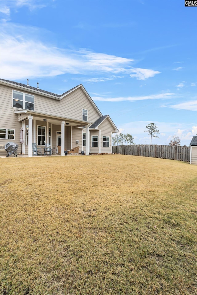 back of house featuring a yard and a patio