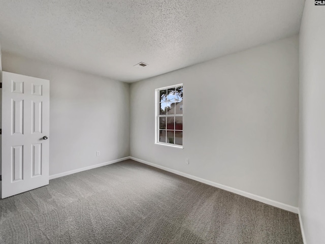 unfurnished room featuring carpet and a textured ceiling