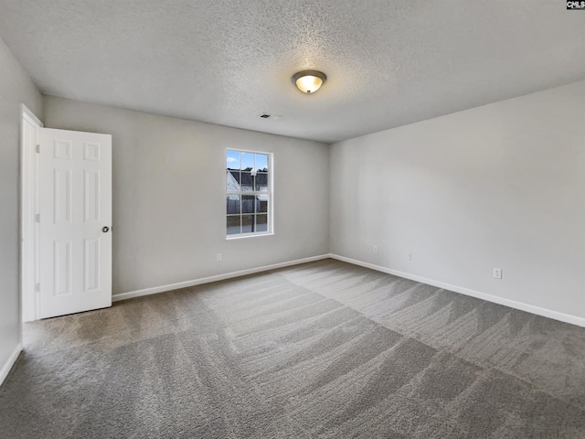 empty room featuring a textured ceiling and carpet floors