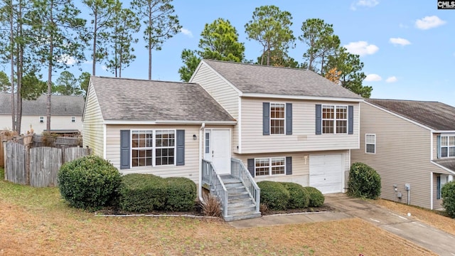 tri-level home with a garage and a front lawn