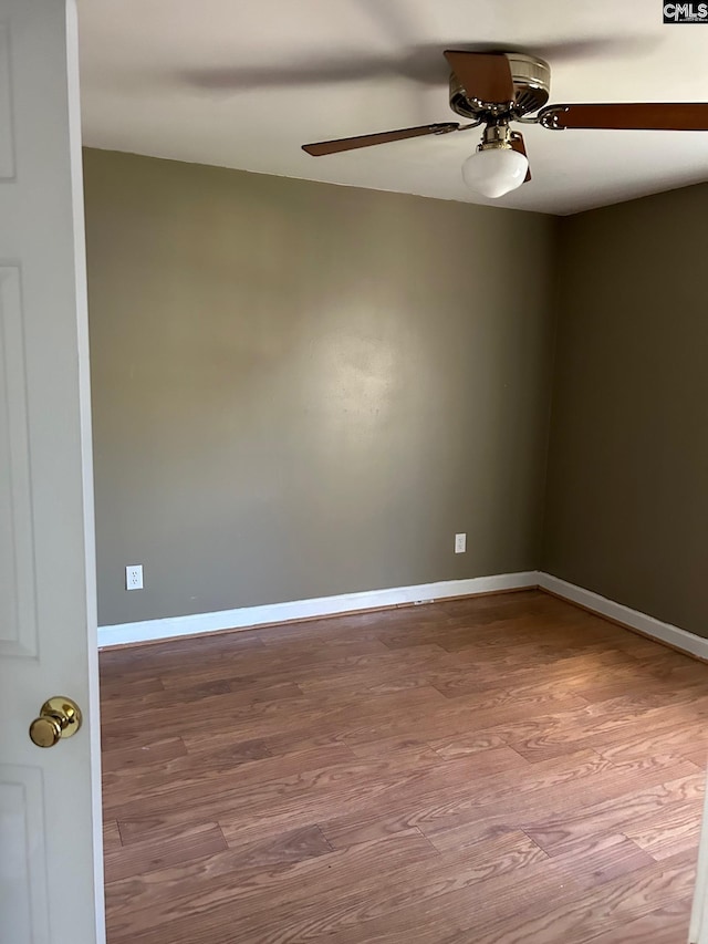 spare room with hardwood / wood-style flooring and ceiling fan