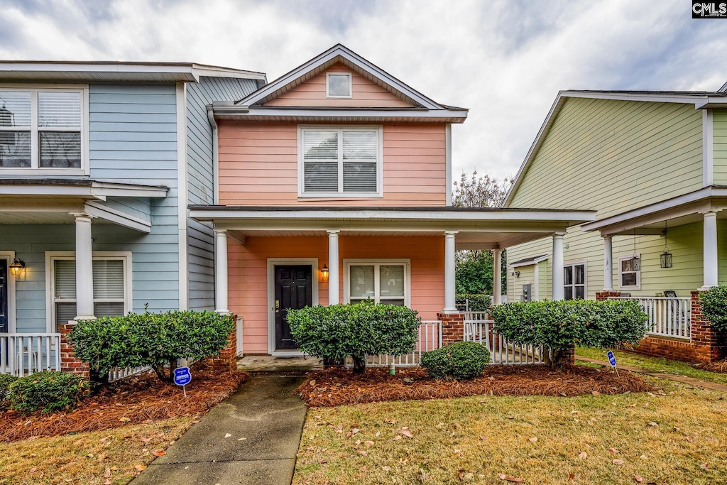 view of front of property featuring covered porch and a front lawn