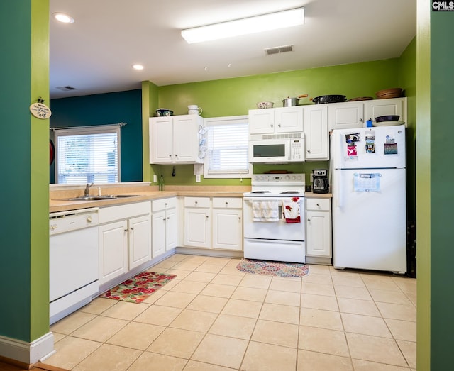 kitchen featuring light tile patterned flooring, white appliances, white cabinetry, and sink