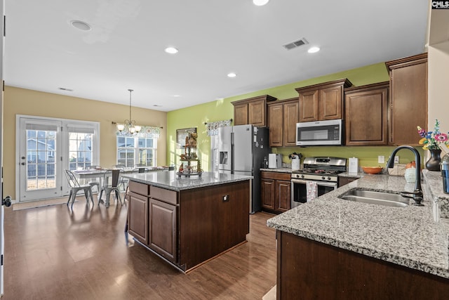 kitchen featuring sink, dark hardwood / wood-style floors, a chandelier, a kitchen island, and appliances with stainless steel finishes