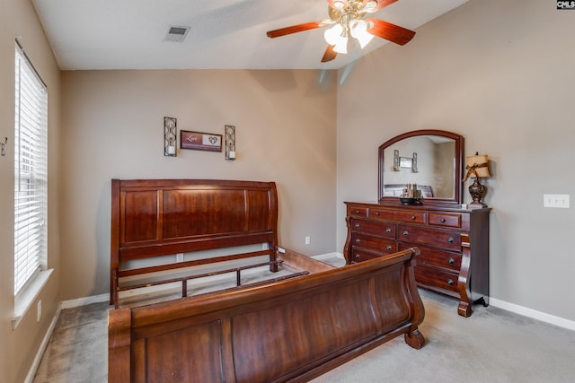 bedroom featuring multiple windows, ceiling fan, light carpet, and vaulted ceiling