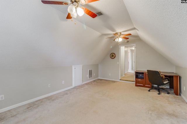 office area featuring ceiling fan, light colored carpet, lofted ceiling, and a textured ceiling