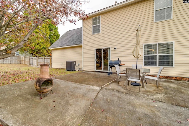 back of property featuring central AC, an outdoor fire pit, and a patio area