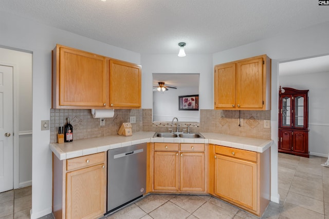 kitchen with tile counters, dishwasher, sink, backsplash, and a textured ceiling